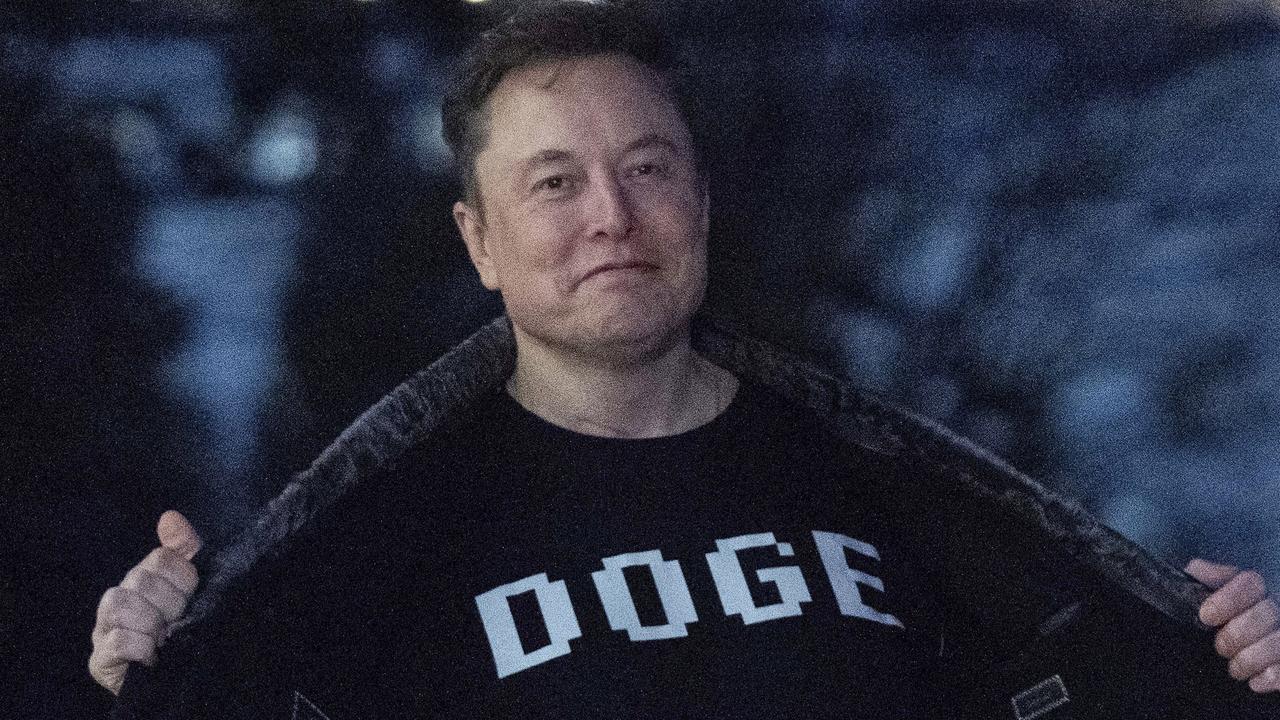 Elon Musk flashes his T-shirt that reads 