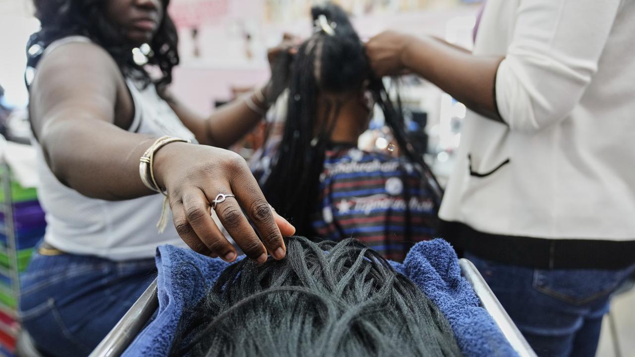 Stylist braiding a woman's hair