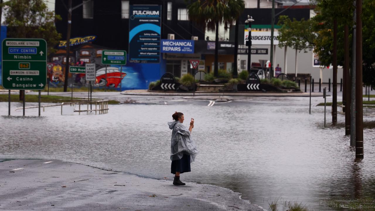 Woman near flooding in Lismore