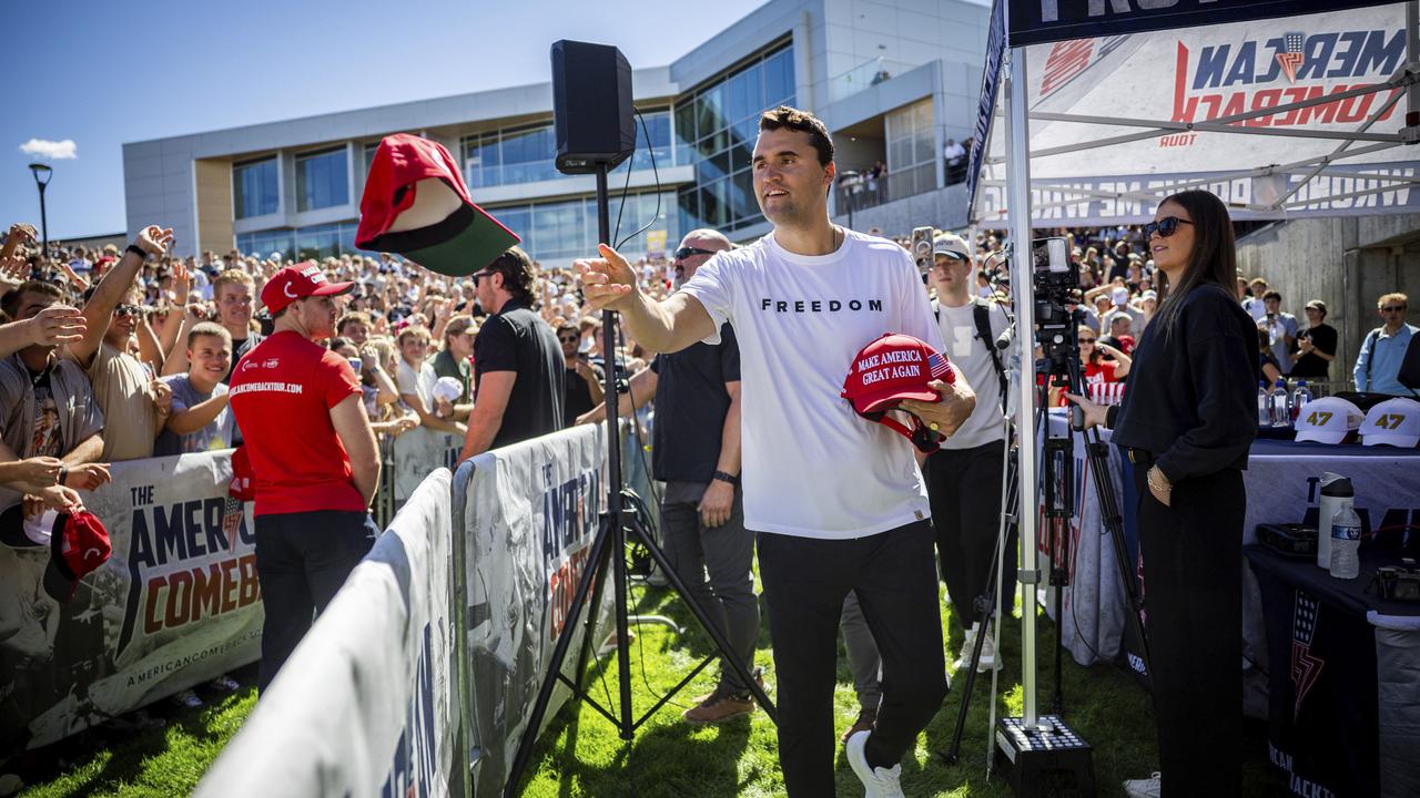 Charlie Kirk hands out hats before speaking at Utah Valley University.