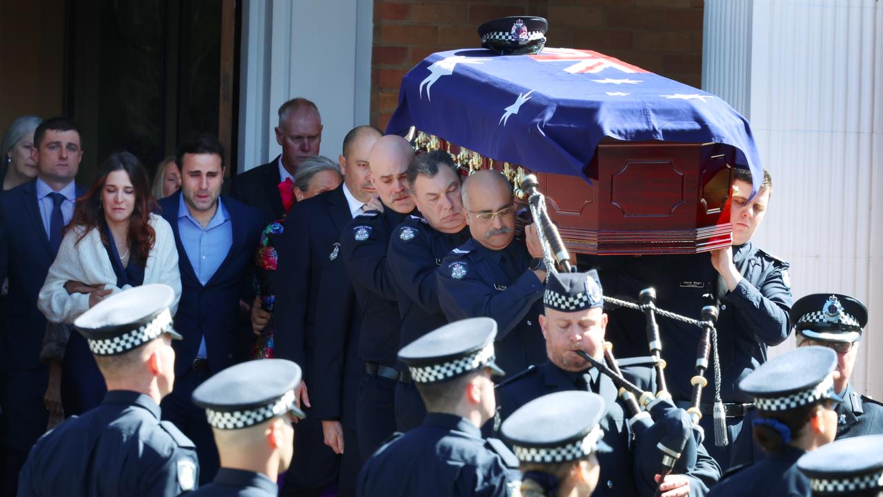Police carry flag draped coffin