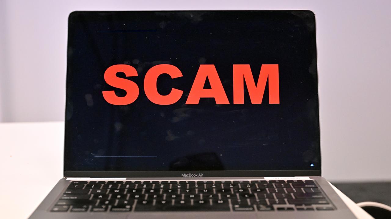 A laptop with the word scam