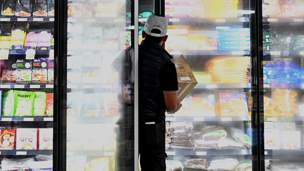 A man stacks a cold storage cabinet at a supermarket in Canberra