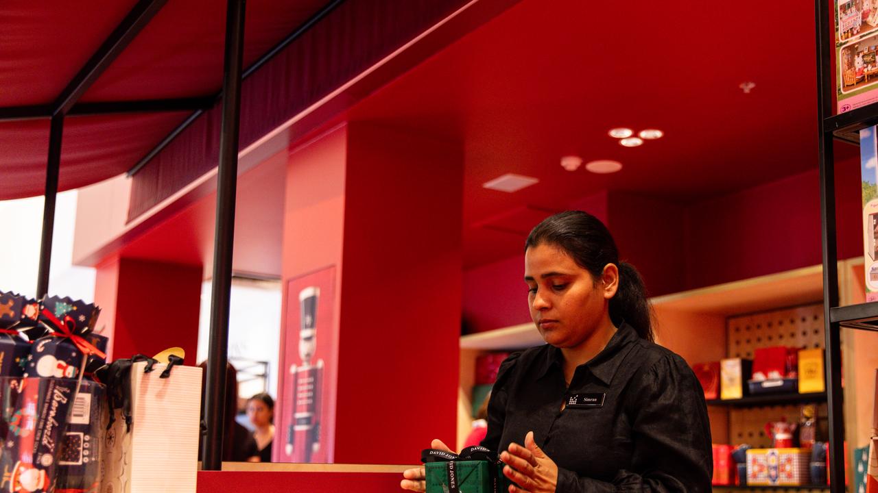 A shop assistant wraps up gifts