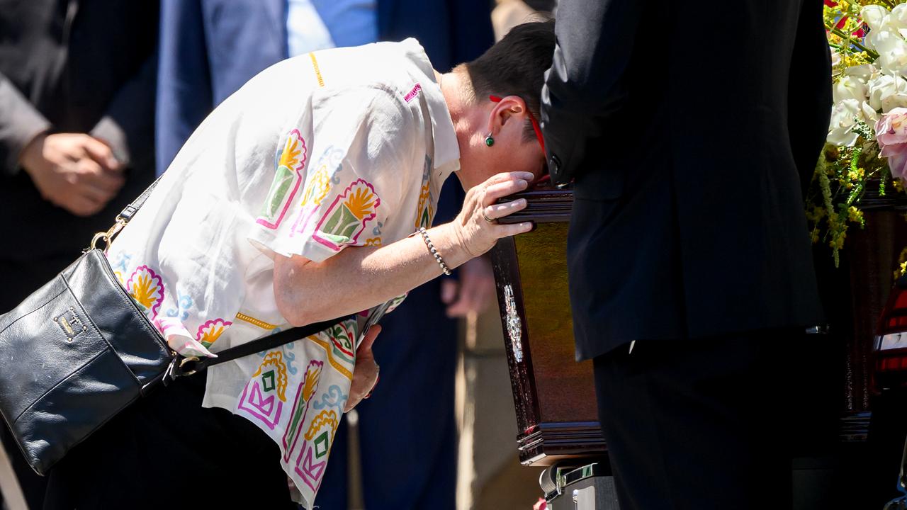 Peter Meagher's widow Virginia Wynne-Markham kisses his coffin