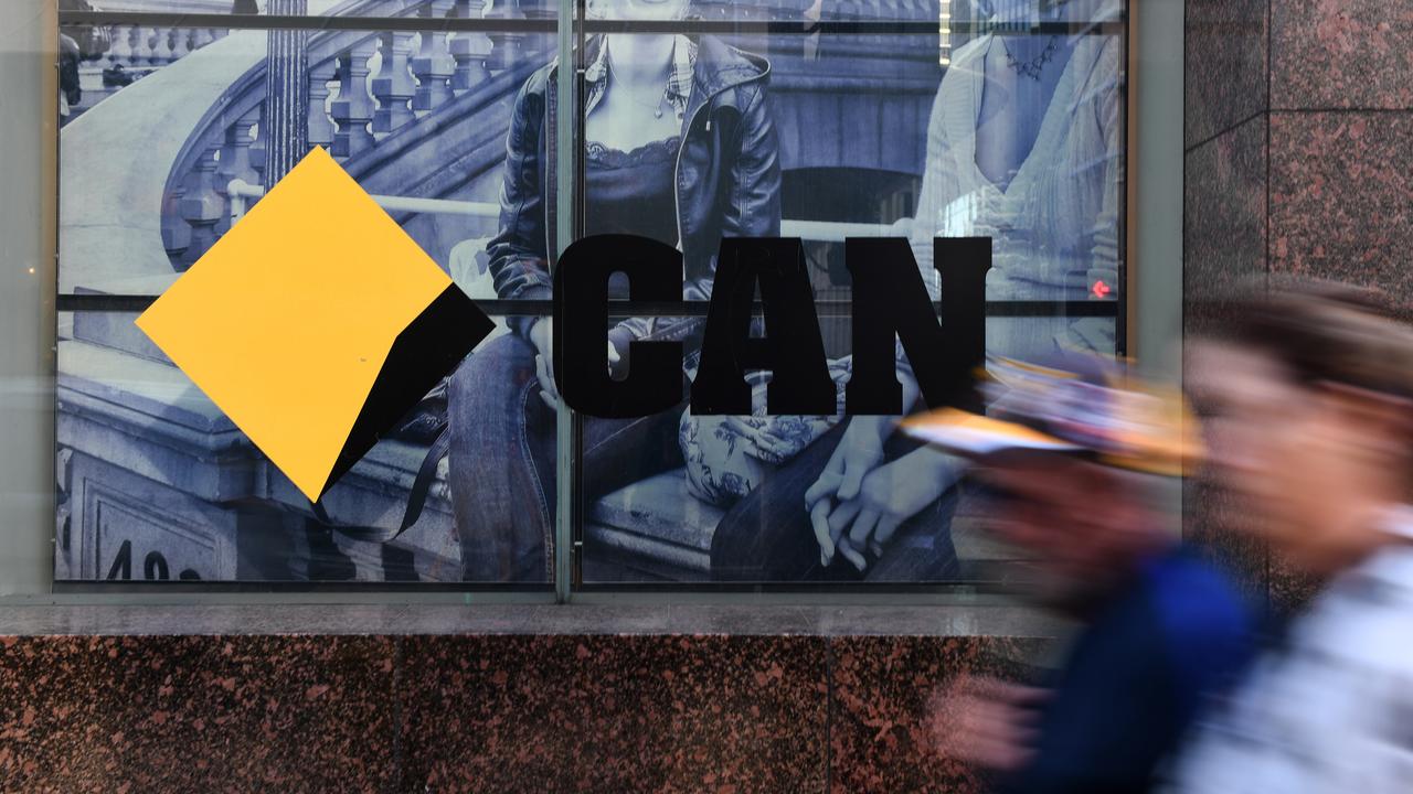 Workers walk past a Commonwealth Bank branch in Sydney