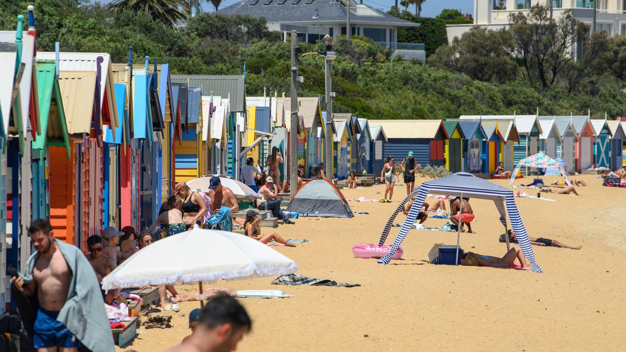 Swimmers seek the shade the Brighton Beach Boxes in Melbourne