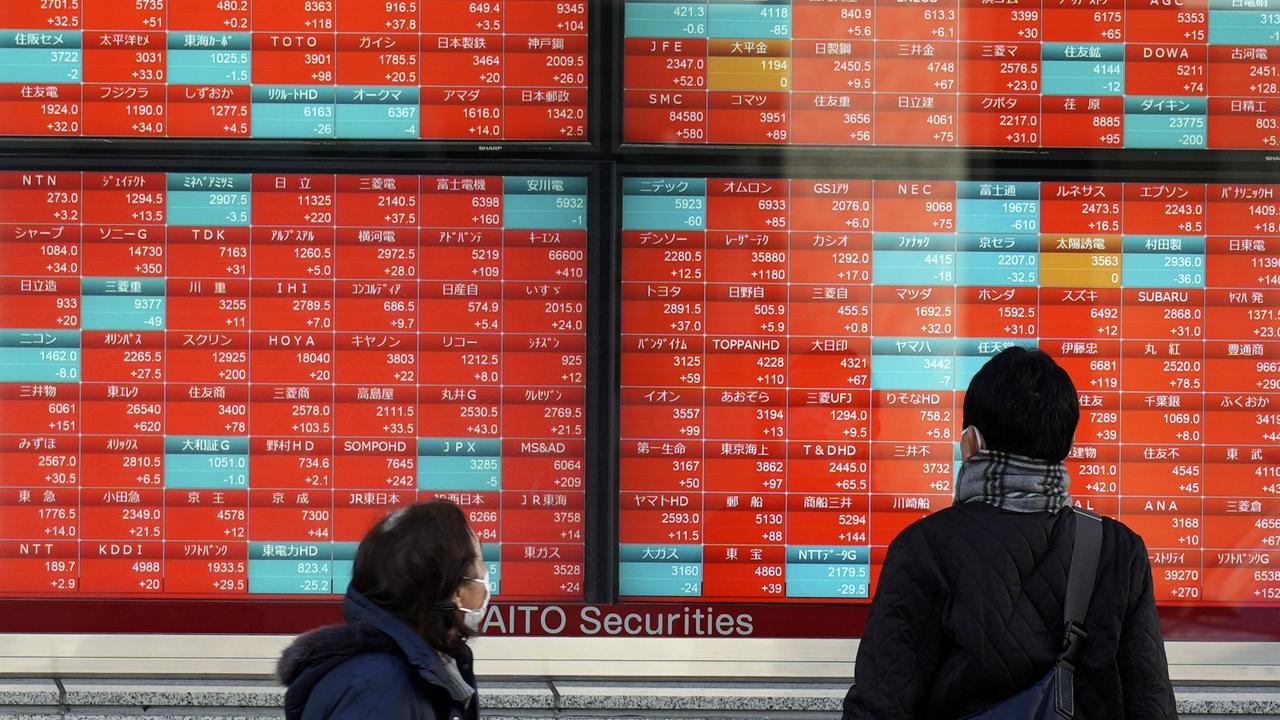 People look at an electronic stock board in Tokyo, Japan