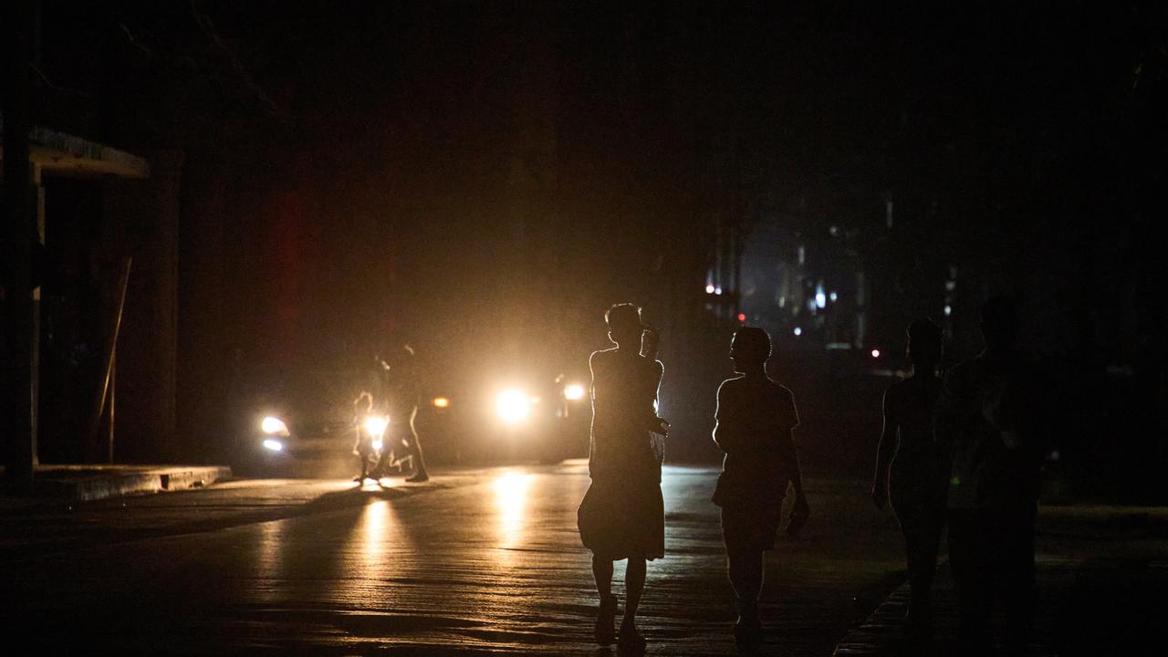 People walk on the street during a blackout in Havana