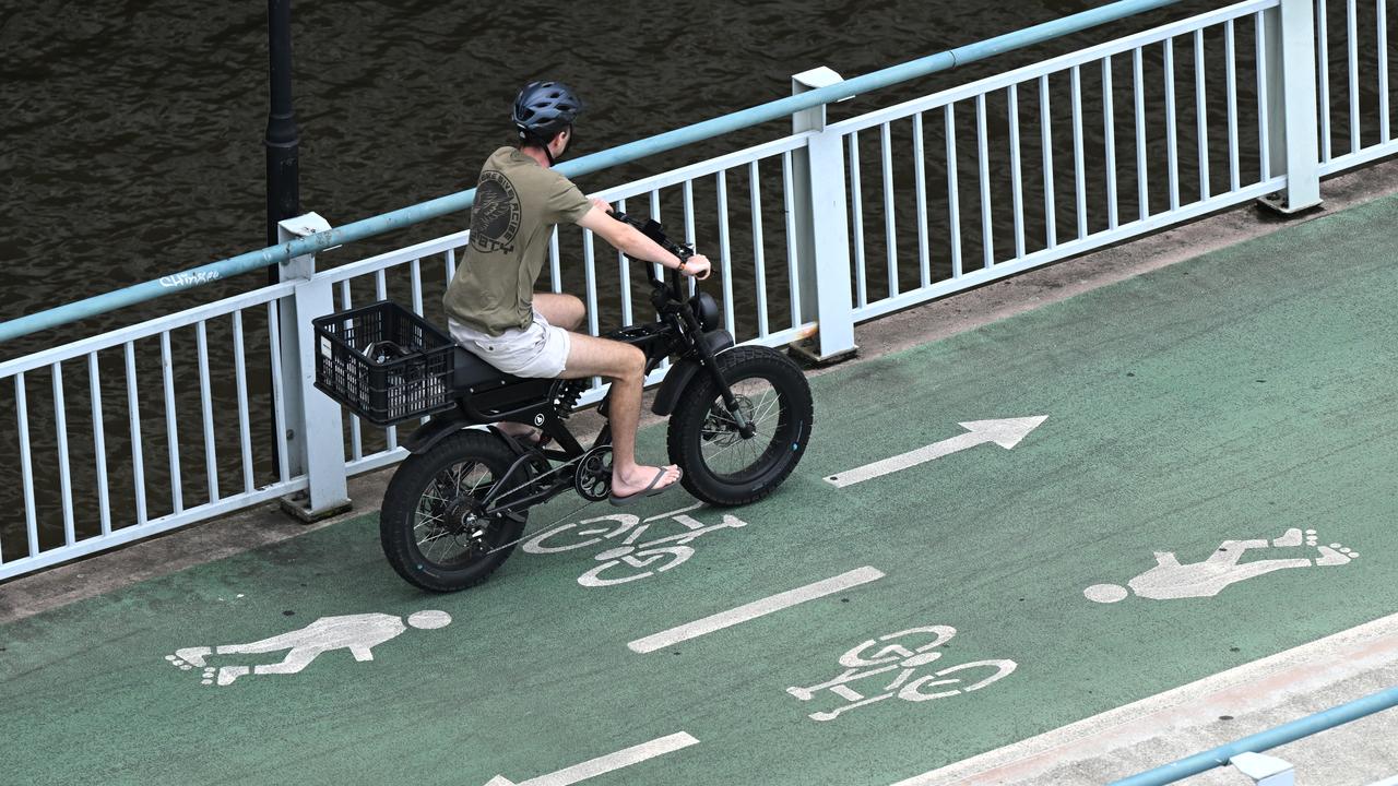 A cyclist rides an e-bike in Brisbane