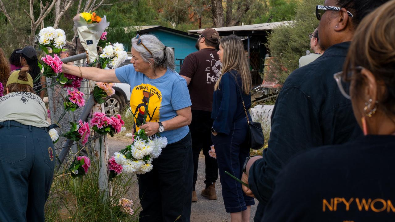 Alice Springs residents place flowers on gates and fences