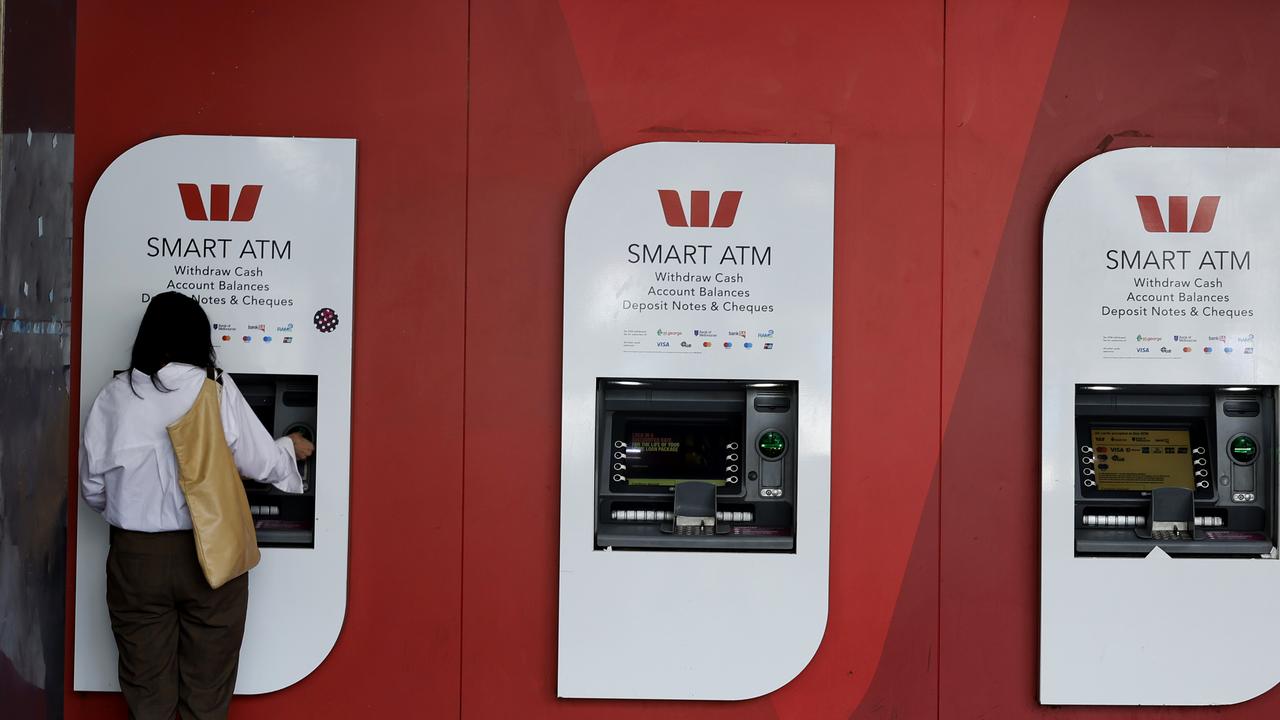 A person is seen on an ATM at a bank branch in Melbourne