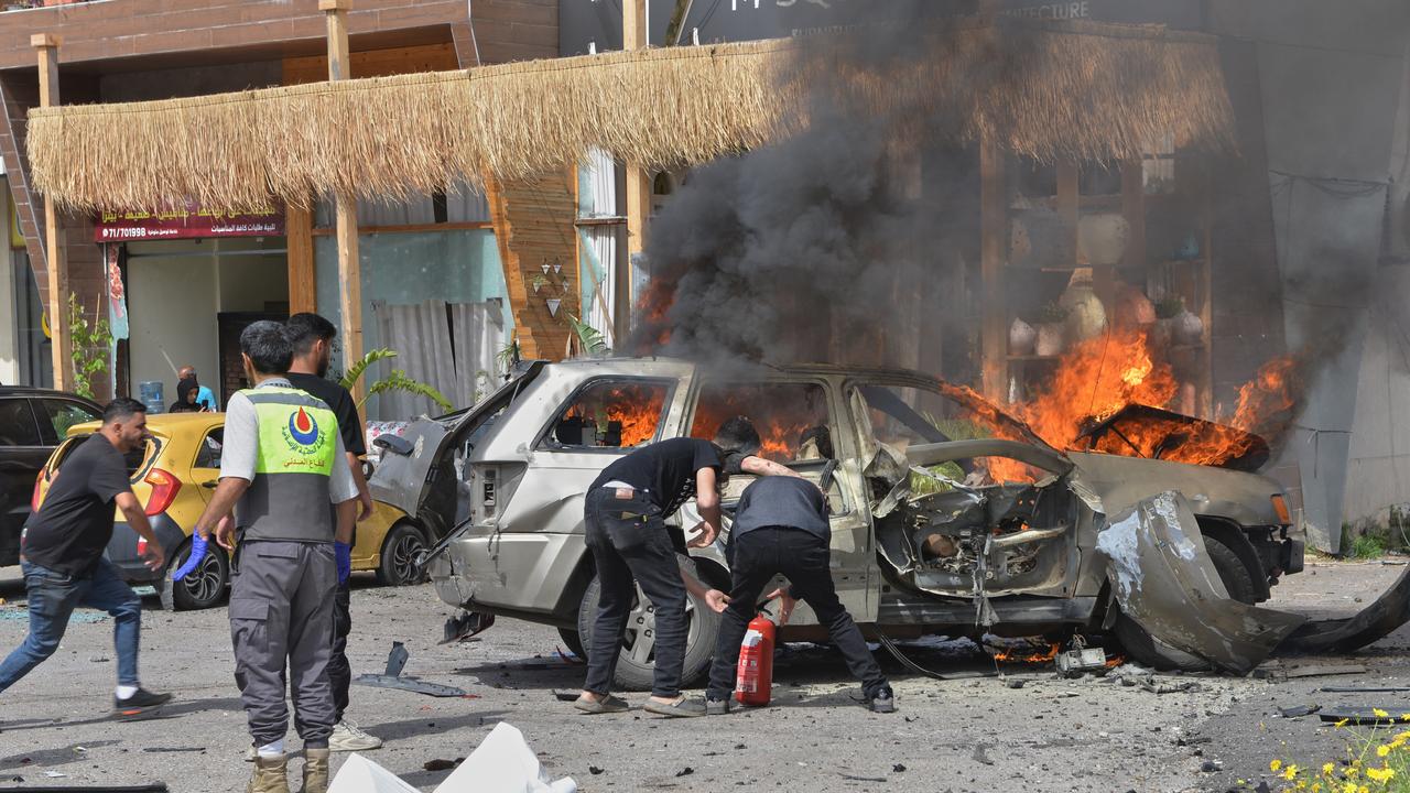 People extinguish a burning car 