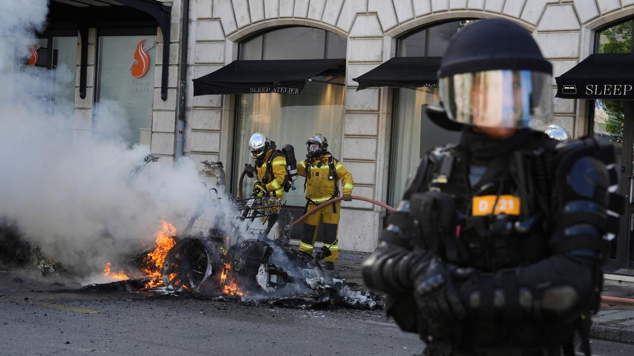 Firefighters deal with a burning Tesla car