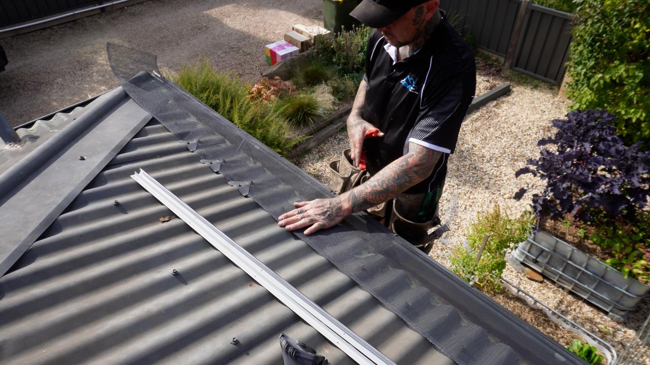 Gutter guards being installed to stop wind-borne burning embers